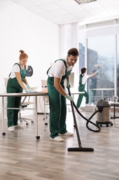 Team of professional janitors working in modern office. Cleaning service