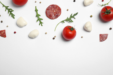 Composition with fresh ingredients for pepperoni pizza on white background, top view
