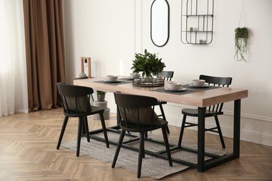 Stylish wooden dining table and chairs in room. Interior design