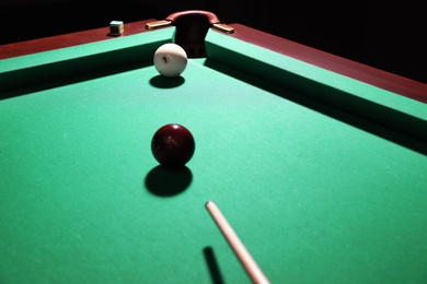 Striking red ball into billiard table pocket