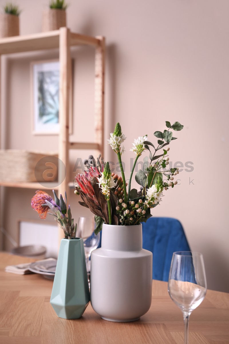 Photo of Vase with beautiful flowers on wooden table indoors. Element of modern interior