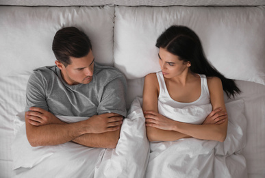Couple with relationship problems in bed at home, top view