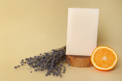 Scented sachet, dried lavender and half of orange on beige background