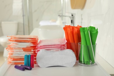 Different feminine hygiene products on counter in bathroom