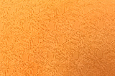 Stylish orange wallpaper as background, top view
