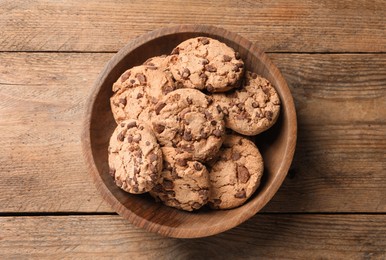 Delicious chocolate chip cookies on wooden table, top view