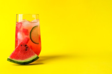 Tasty summer watermelon drink with lime in glass on yellow background. Space for text