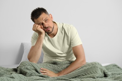 Photo of Sleepless man sitting on bed at home