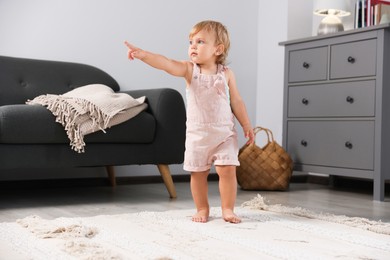 Cute baby learning to walk in living room