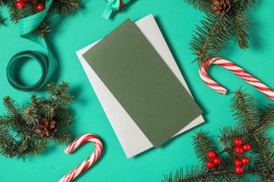 Flat lay composition with blank greeting card and Christmas decor on green background, space for text