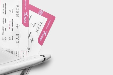 Toy airplane and tickets on white background, flat lay with space for text. Travel agency concept