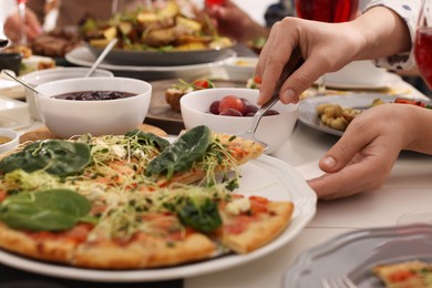 Woman taking slice of pizza during brunch at table, closeup