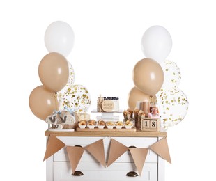 Baby shower party. Different delicious treats on chest of drawers and decor against white background