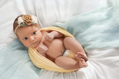 Photo of Adorable newborn baby on bed, top view
