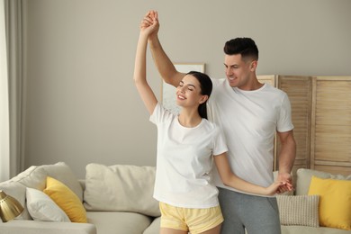 Photo of Happy couple in pyjamas dancing at home
