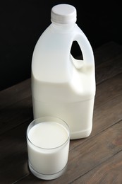 Gallon bottle and glass of milk on wooden table