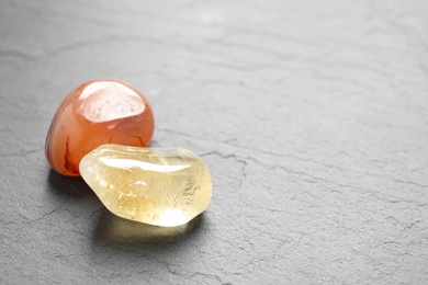Photo of Orange gemstones on grey table, space for text