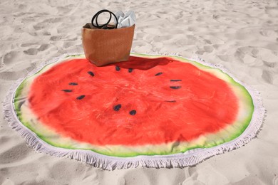 Beautiful watermelon beach towel with tassels, bag and flip flops on sand