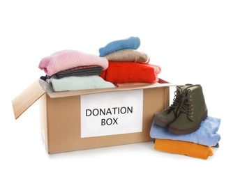 Donation box, shoes and clothes on white background