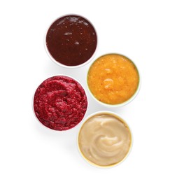 Different fruit and berry puree in bowls on white background, top view