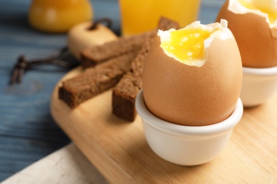 Holder with soft boiled egg on table. Space for text