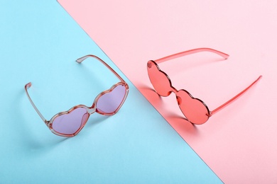 Funky heart shaped sunglasses on color background