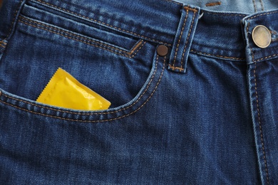 Closeup view of jeans with condom in pocket. Safe sex concept