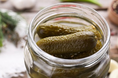 Tasty pickled cucumbers in jar on table, closeup