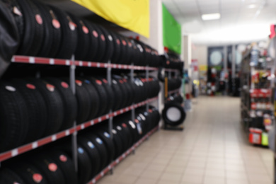 Blurred view of car tires on rack in auto store