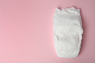 Photo of Baby diaper on pink background, top view. Space for text