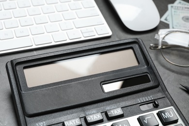 Calculator and keyboard on dark grey table, closeup. Tax accounting