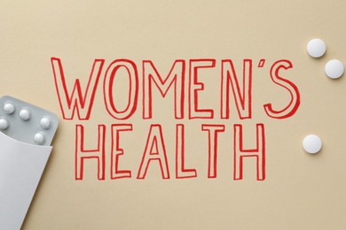 Words Women's Health and pills on beige background, flat lay