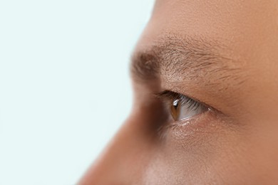 Closeup view of man with beautiful eye on blurred background. Space for text