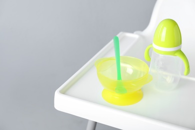 Set of plastic dishware on white feeding table. Serving baby food