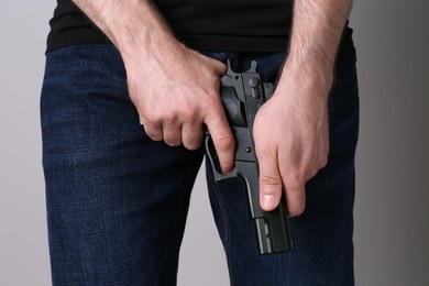 Man reloading gun on grey background, closeup