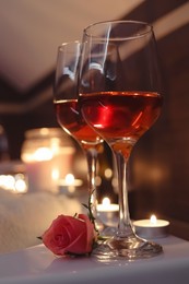 Glasses of wine and rose on tub in bathroom. Romantic atmosphere