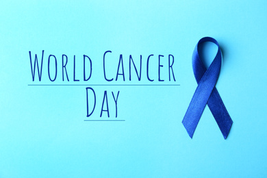 Blue ribbon on color background, top view. World Cancer Day