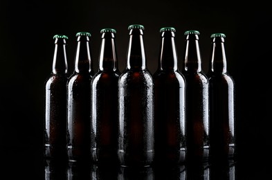 Photo of Many bottles of beer on table against dark background