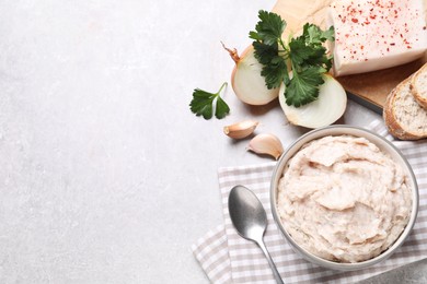 Photo of Delicious lard spread in bowl on light table, flat lay. Space for text