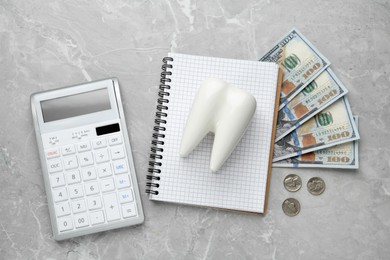 Flat lay composition with ceramic model of tooth and money on grey table. Expensive treatment