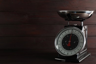 Retro mechanical kitchen scale on wooden table, space for text