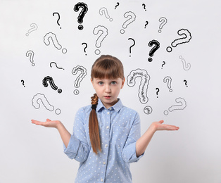 Emotional girl with drawings of question marks on white background