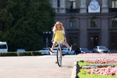 Beautiful happy woman riding bicycle on street