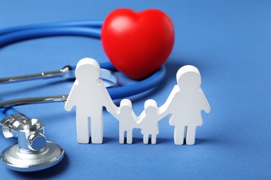 Family figure with stethoscope and heart on color background. Life insurance concept