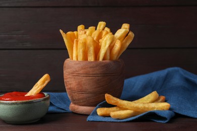 Photo of Bowl of french fries with ketchup on black table