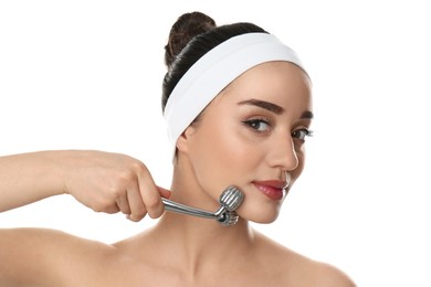 Woman using metal face roller on white background