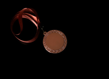 Bronze medal on black background, top view. Space for design