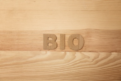 Photo of Word "Bio" made of cardboard letters on wooden background, top view