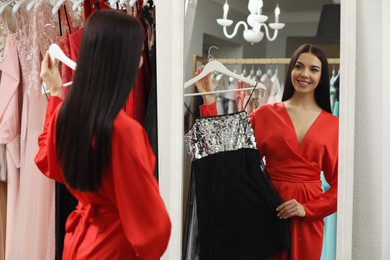 Woman choosing dress in rental clothing salon