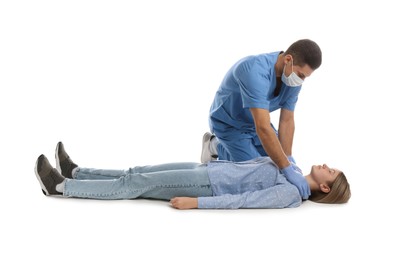 Doctor in uniform practicing first aid on woman against white background